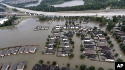 Homes are surrounded by floodwaters from Tropical Storm Harvey, Aug. 29, 2017, in Spring, Texas. Congress is considering renewing the National Flood Insurance Program.