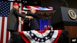FILE - President Donald Trump gets ready to embrace U.S. Senate candidate Luther Strange during a campaign rally, in Huntsville, Alabama, Sept. 22, 2017.