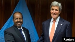 U.S. Secretary of State John Kerry (R) and Somalia's President Hassan Sheikh Mohamud shake hands before a meeting at Addis Ababa Bole International Airport, May 3, 2014.