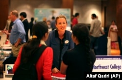 Indian students listen to a representative of Northwest College during a U.S. University fair organized by EducationUSA in New Delhi, India, Saturday, November. 3, 2012.