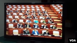 រូបឯកសារ៖ តាមកញ្ចក់ទូរទស្សន៍មួយ សមាជិករដ្ឋសភាបានលើកដៃបោះឆ្នោតគាំទ្រសេចក្តីស្នើច្បាប់ស្តីពីវិសោធនកម្មច្បាប់ស្តីពីលក្ខន្តិកៈមន្រ្តីរាជការនៃក្រុមនីតិបញ្ញត្តិ ក្នុងកិច្ចប្រជុំនាព្រឹកថ្ងៃសុក្រ ទី៧ ខែមេសា ឆ្នាំ២០១៧។ (អ៊ិត សូធឿត/VOA)