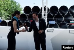 Greece's Prime Minister Alexis Tsipras prepares to sign during the Trans Adriatic Pipeline inauguration ceremony, in the northern Greek city of Thessaloniki, May 17, 2016.