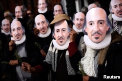People hold up face masks with William Shakespeare's portrait during celebrations to mark the 400th anniversary of the playwright's death in the city of his birth, Stratford-Upon-Avon, Britain, April 23, 2016.