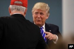 Republican presidential candidate Donald Trump talks to a guest during his visit to Kent County Republican Headquarters in Grand Rapids, Mich., Sept. 30, 2016.