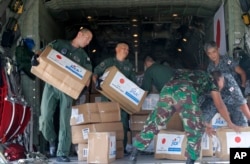 Indonesian and Japan military personnel unload relief aid from a Japan Air Force cargo plane at the Mutiara Sis Al-Jufri airport in Palu, Central Sulawesi, Indonesia, Oct. 6, 2018.