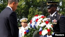 U.S. President Barack Obama (L) bows his head after laying a wreath on the 60th anniversary of the end of the Korean War, at the Korean War Veterans Memorial in Washington, July 27, 2013.
