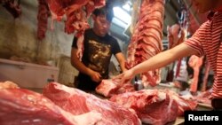 A customer chooses a cut of beef at a meat market in Beijing, May 2013. With more money in their pockets, millions of Chinese are seeking a richer diet and switching to beef. (FILE PHOTO)