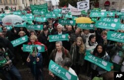 Poland MigrantsPeople take part in a demonstration in support of migrants holding up placards saying 'Refugees welcome' in front of the Mikolaj Kopernik's statue in Warsaw, Poland, Saturday, Sept. 12, 2015.