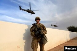 A U.S. Army soldier stands with his weapon at a military base in the Makhmour area near Mosul during an operation to attack Islamic State militants in Mosul, Iraq, Oct. 18, 2016.