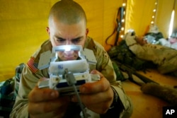 FILE - Pfc. Ralph Abbatiello of Long Island, New York, plays Pokemon while awaiting deployment at a camp in Kuwait, April 3, 2003.