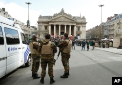 Tentara Belgia berjaga-jaga di samping tempat untuk mengenang korban serangan Brussels baru-baru ini, di Place de la Bourse di Brussels, 27 Maret 2016.