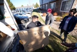 Relawan Tim Rubicon Jordon Daniel (kiri), Nicholas Duchnowski dari Broomfield, Colorado, (tengah), dan Bill Medina dari Denver, memindahkan barang-barang ke sebuah apartemen yang akan menjadi rumah bagi para pengungsi Afghanistan Rabu, 10 November 2021, di pinggiran utara Denver, Thornton, Colorado. (AP/David Zalubowski)