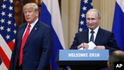 FILE - U.S. President Donald Trump, left, and Russian President Vladimir Putin arrive for a press conference after their meeting at the Presidential Palace in Helsinki, Finland, July 16, 2018.