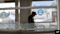 A military officer inspects a bus stop damaged in Wednesday's suicide bombings in Jakarta, Indonesia, May 25, 2017. Indonesia's President Joko "Jokowi" Widodo ordered a thorough investigation of the network behind two suicide bombings that targeted police.