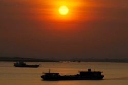 FILE - A dredging river barge, foreground, carries sand in the middle of Mekong River near Phnom Penh, Cambodia, Friday, Jan. 24, 2020. (AP Photo/Heng Sinith)