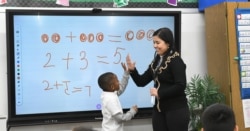 Teaching assistant Dilia Samadova teaches a math lesson in Mrs. Zenobi's kindergarten class at Our Lady of Peace School, Dec.11, 2019.