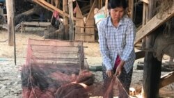 អ្នកស្រីងុន ឈឺនវ័យ៥២ ឆ្នាំកំពុងជួយជុសជុលលបសម្រាប់ចាប់ត្រីរបស់លោក​សុខ ថុល។ (ហ៊ុល រស្មី/VOA)