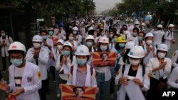 Protesters take cover during clashes with security forces in Monywa, Myanmar, March 21, 2021, in this still image from a video obtained by Reuters.