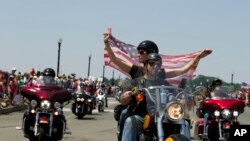 អ្នកចូលរួម​​នៅ​ក្នុង​ក្បួន​ម៉ូតូធំ​ប្រចាំ​ឆ្នាំ​ធ្វើ​ដំណើរ​ឆ្លងកាត់​ស្ពាន​រំឮកវិញ្ញាណក្ខន្ធ​ Arlington នៅ​អំឡុងពេល​ដង្ហែក្បួន​​មុន​ពេល​​ថ្ងៃរំឮក​វិញ្ញាណក្ខន្ធ​អតីត​យុទ្ធ​ជន​​នៅ​រដ្ឋធានី​វ៉ាស៊ីនតោន។ 