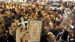 En Egypte des musulmans et des chrétiens lors d'une manifestation pour protester contre l'attaque d'une eglise copte à Alexandrie.