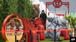 A man watches over a set promoting the Disney movie "Mulan" in Beijing on Wednesday, Feb. 19, 2020. (AP Photo/Ng Han Guan)