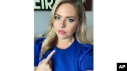 In this July 23, 2020 selfie provided by Victoria Price, Price, a reporter for WFLA in Tampa, Fla., points to her neck. The television news reporter is crediting an eagle-eyed viewer for noticing a lump on her neck and emailing her that she should get it 