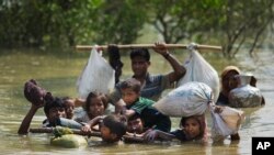 Sebuah keluarga Rohingya berhasil mencapai Teknaf, Bangladesh setelah berhari-hari melakukan perjalanan melalui sungai Naf di Myanmmar, Selasa (5/9). 