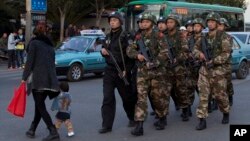 Policemen and paramilitary policemen patrol a street near the Kunming Railway Station, where more than 10 assailants slashed scores of people with knives Saturday evening, in Kunming, in southwestern China's Yunnan province, March 3, 2014.