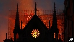Flames and smoke rise from Notre Dame cathedral as it burns in Paris, Monday, April 15, 2019. (AP Photo/Thibault Camus)
