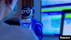 A North Korean student sits in front of a robot in Pyongyang, North Korea November 3, 2021, in this still image obtained from Reuters. (REUTERS TV/KRT)