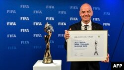 Presiden IFA Gianni Infantino berpose di samping Trofi Piala Dunia Wanita setelah pengumuman bahwa Australia/Selandia Baru adalah tuan rumah pemenang Piala Dunia Perempuan FIFA 2023. (Foto: AFP)