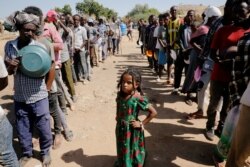 FILE -[ Ethiopian refugees wait in lines for a meal at the Umm Rakouba refugee camp, which houses Ethiopian refugees fleeing the fighting in the Tigray region, on the Sudan-Ethiopia border, Nov. 28, 2020.