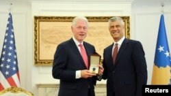 Kosovo President Hashim Thaci honors Bill Clinton with a medal during the event marking the 20th anniversary of NATO peacekeeping mission in Kosovo, in Pristina, June 11, 2019. 