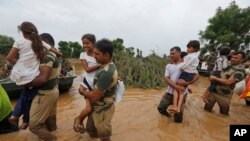 A pink flamingo with flamingos chicks in a pen in Aigues-Mortes, near Montpellier, southern France, Aug. 5, 2020.