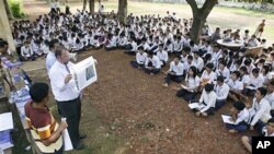 The officers of U.N.-backed genocide tribunal meet high school students at Ek Phnom district in Battambang province, as they distribute recent verdict books of Khmer Rouge leader Kaing Guek Eav, northwest of Phnom Penh, Cambodia, May 5, 2011