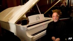 Billy Joel poses et son piano à New York (Photo AP)