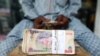 A money changer counts Nigerian currency notes for a customer in Nigeria's commercial capital, Lagos, Nigeria, March 16, 2020.