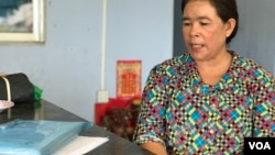 អ្នកស្រី ឡុង សុគន្ធី សម្លឹង​មើល​សំណុំរឿង​តុលាការ​នៅក្នុង​ផ្ទះ​របស់​អ្នកស្រី​ក្នុង​ឃុំ​អូរបីជាន់​ ស្រុកអូរជ្រៅ​ ខេត្តបន្ទាយ​មាន​​ជ័យ​ ថ្ងៃទី​២៦ ខែឧសភា​ ឆ្នាំ២០២០។ (ហ៊ុល រស្មី/VOA)