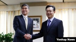 미국의 북핵 6자회담 수석대표인 성 김 미국 국무부 대북정책 특별대표 겸 동아시아·태평양담당 부차관보(왼쪽)가 5일 서울 외교부에서 한국측 대표인 황준국 외교부 한반도평화교섭본부장과악수하고 있다.