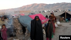 រូបឯកសារ៖ ក្រុម​គ្រួសារ​អាហ្វហ្គានីស្ថាន​ដែល​បាន​រត់ចោល​ទីលំនៅ​ឈរ​នៅ​ខាង​ក្រៅ​តង់​ស្នាក់នៅ​បណ្ដោះអាសន្ន​របស់​ពួកគេ​ក្នុង​ខេត្ត Herat ប្រទេស​អាហ្វហ្គានីស្ថាន ថ្ងៃទី១៤ ខែតុលា ឆ្នាំ២០១៨។