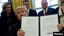U.S. President Donald Trump holds an executive order dealing with the structure of the National Security Council after signing it in the Oval Office at the White House in Washington, Jan. 28, 2017. 