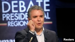 FILE - Candidate for the Presidency of Colombia Ivan Duque speaks in the first presidential debate, broadcast by the regional channel Teleantioquia, in Medellin, Colombia, April 3, 2018. Duque said recently that assailants planned to attack his campaign headquarters with explosives.