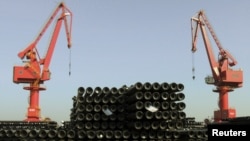 FILE - Cranes are seen above piles of steel pipes to be exported at a port in Lianyungang, Jiangsu province, China, Dec. 1, 2015. 