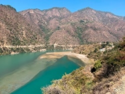 Rescuers leave on a boat to search for bodies in the downstream of Alaknanda River in Rudraprayag, northern state of Uttarakhand, India, Feb.8, 2021.