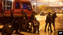 Thai police stand behind a truck outside Terminal 21 Korat mall, in Nakhon Ratchasima, Thailand, Feb. 9, 2020. A soldier who holed up in the mall shot multiple people on Saturday, killing at least 21, officials said.
