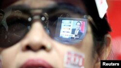 Hasil perolehan pemilu Thailand terpantul dari kacamata yang dikenakan oleh seorang pendukung partai Pheu Thai di Bangkok, Thailand, 24 Maret 2019. (Foto: dok).