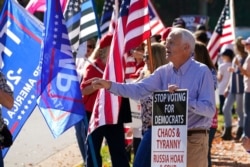 A supporter of President Donald Trump argues with a President-elect Joe Biden supporter at the entrance to Trump National Golf Club in Sterling, Va., Nov. 7, 2020. Trump was at the facility.
