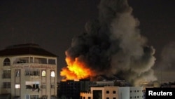 Smoke rises from a tower after it was hit by Israeli airstrikes amid a flare-up of Israeli-Palestinian violence, in Gaza City, May 12, 2021. 