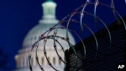 FILE - Riot fencing and razor wire reinforce the security zone on Capitol Hill in Washington, Jan. 19, 2021. Capitol Police say they are stepping up security at D.C.-area transit hubs and taking other steps to bolster travel security for lawmakers.