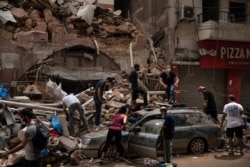 People remove debris from a house damaged by Tuesday's explosion in the seaport of Beirut, Lebanon, Aug. 7, 2020.